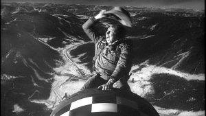 Questa iconica scena mostra l'attore Slim Pickens nel ruolo del Maggiore T.J. "King" Kong che cavalca una bomba atomica agitando il cappello da cowboy nel capolavoro satirico di Stanley Kubrick